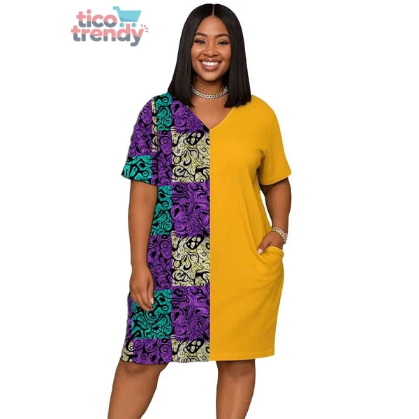 Mujer vistiendo un vestido casual de corte midi con diseño bicolor, combinando un lado liso en color amarillo con bolsillos y el otro con un estampado tradicional en tonos morados, turquesas y negros.