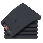 Una pila de cinco pantalones de vestir formales o de traje de hombre de color gris oscuro o carbón.