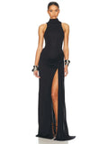 Vestido largo de noche negro, cuello alto (halter) sin mangas, con drapeado fruncido en la cadera y abertura alta en la pierna.